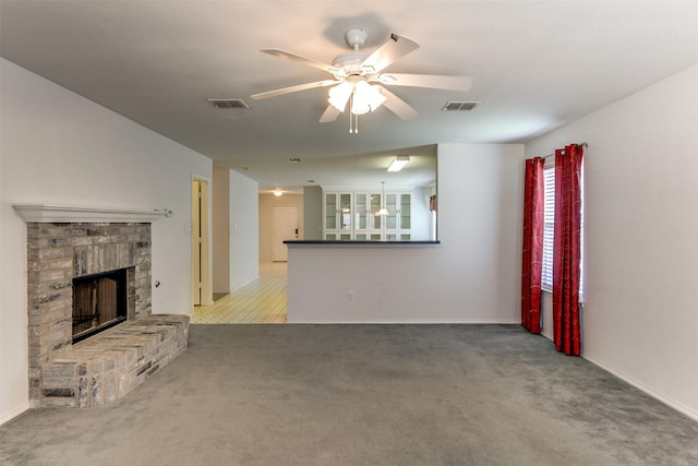 unfurnished living room featuring a ceiling fan, a brick fireplace, visible vents, and carpet flooring