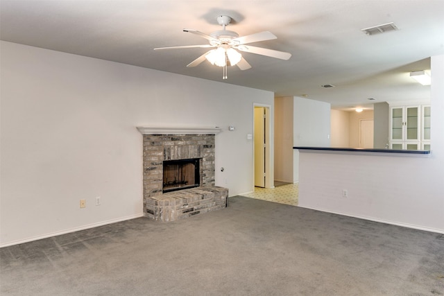 unfurnished living room featuring a fireplace, visible vents, a ceiling fan, carpet flooring, and baseboards