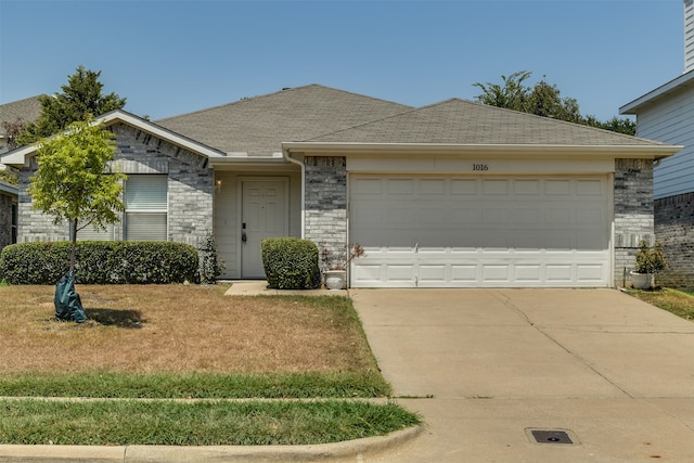 single story home with a garage and a front lawn