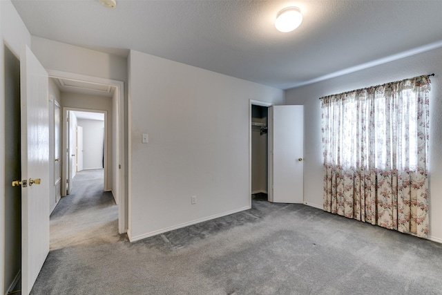 unfurnished bedroom featuring attic access, a closet, and light carpet