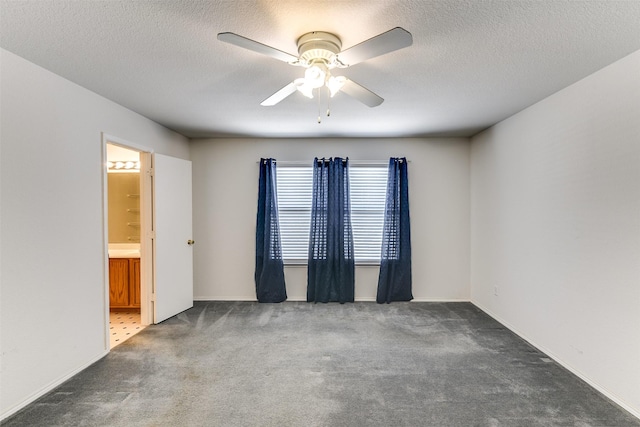 unfurnished room featuring a textured ceiling, carpet floors, and a ceiling fan