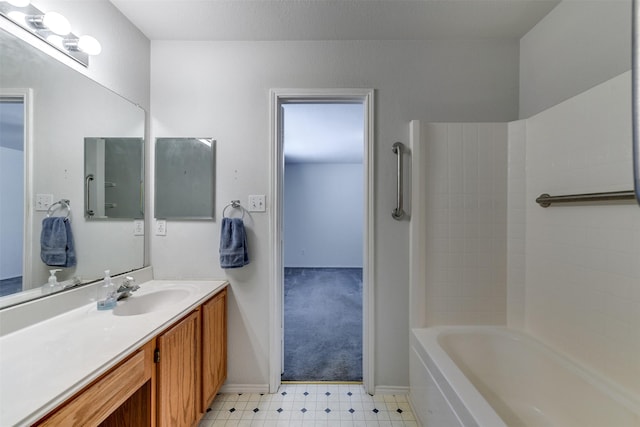 full bath with vanity, baseboards, and tile patterned floors