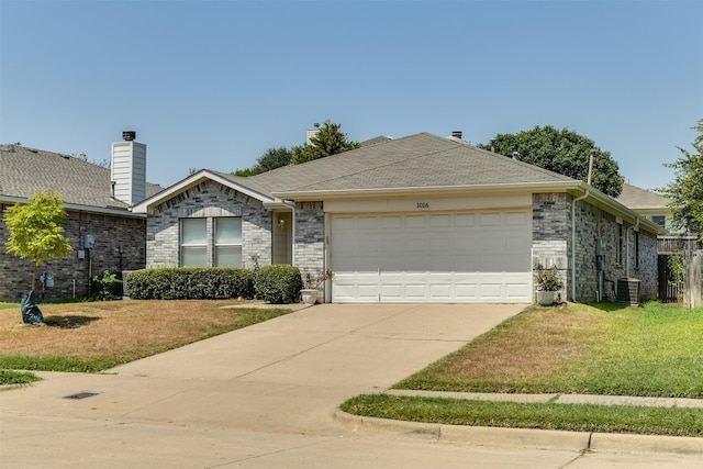 ranch-style home with a shingled roof, central AC unit, concrete driveway, an attached garage, and a front yard