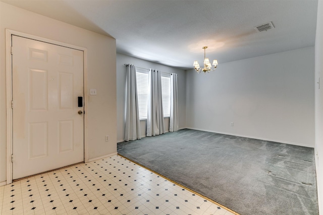 entryway with baseboards, light colored carpet, visible vents, and an inviting chandelier