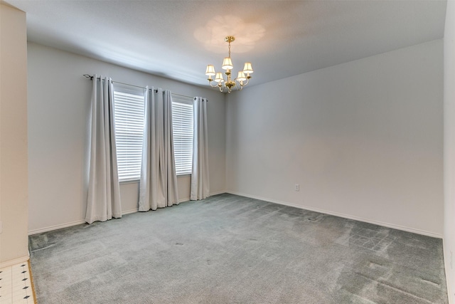 carpeted spare room with baseboards and a notable chandelier