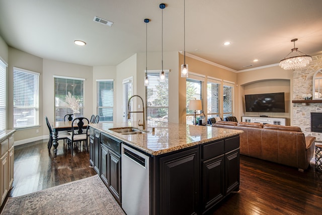 kitchen featuring dishwasher, a kitchen island with sink, dark wood-type flooring, hanging light fixtures, and sink