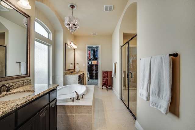 bathroom featuring plus walk in shower, vanity, and a notable chandelier