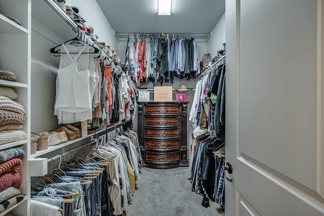 walk in closet featuring light colored carpet