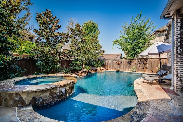 view of pool with a patio area and an in ground hot tub