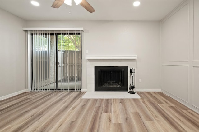 unfurnished living room featuring a fireplace, ceiling fan, and light wood-type flooring