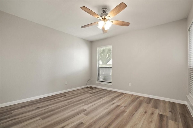 empty room with a ceiling fan, baseboards, and wood finished floors