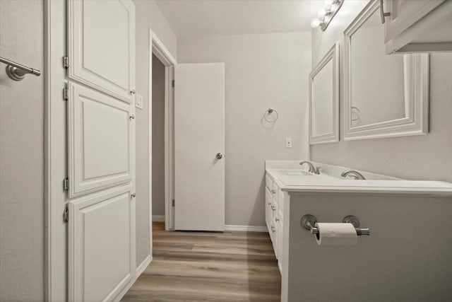 bathroom featuring vanity, wood finished floors, and baseboards