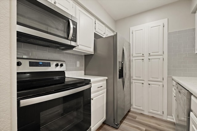 kitchen featuring light hardwood / wood-style floors, appliances with stainless steel finishes, tasteful backsplash, and white cabinetry