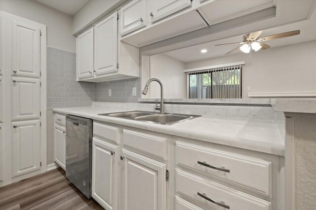 kitchen with a sink, white cabinetry, light countertops, and stainless steel dishwasher