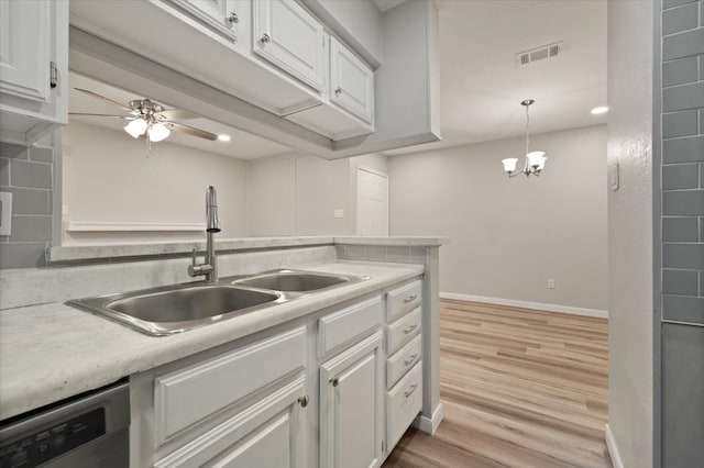 kitchen featuring sink, decorative light fixtures, light hardwood / wood-style flooring, ceiling fan with notable chandelier, and white cabinetry