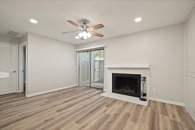 unfurnished living room with visible vents, baseboards, wood finished floors, and a fireplace with flush hearth