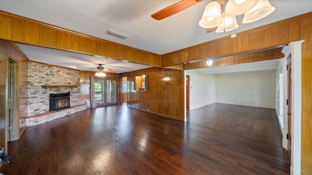 unfurnished living room with a ceiling fan, visible vents, crown molding, and wood finished floors