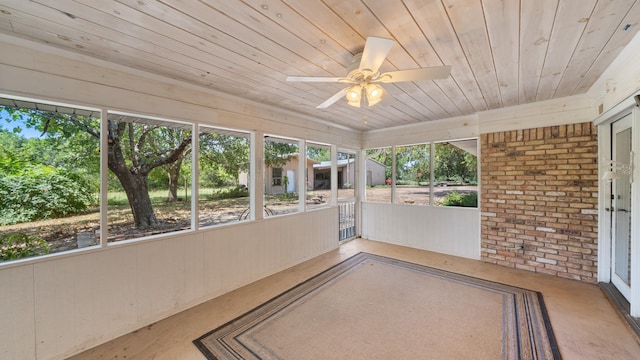 unfurnished sunroom with wood ceiling and a ceiling fan