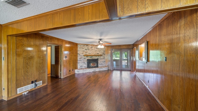 unfurnished living room with visible vents, a textured ceiling, and wood finished floors