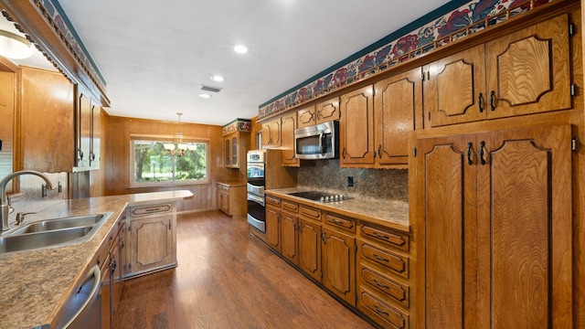 kitchen featuring visible vents, appliances with stainless steel finishes, brown cabinets, dark wood-type flooring, and a sink