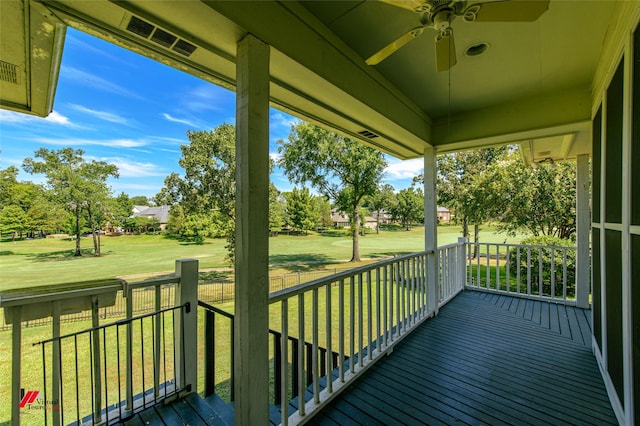 wooden terrace featuring a yard and ceiling fan