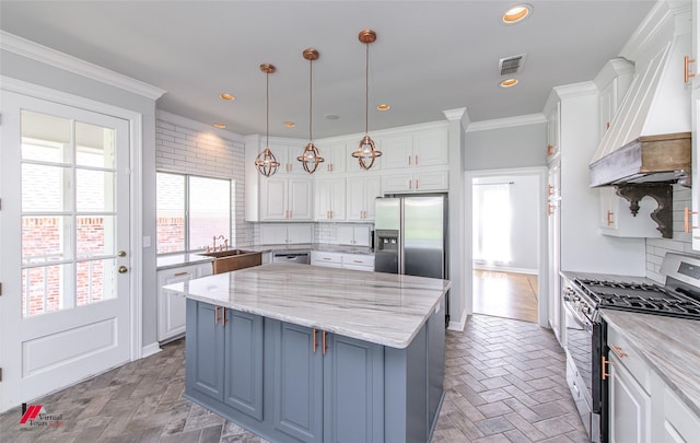 kitchen with visible vents, white cabinets, a kitchen island, appliances with stainless steel finishes, and custom exhaust hood