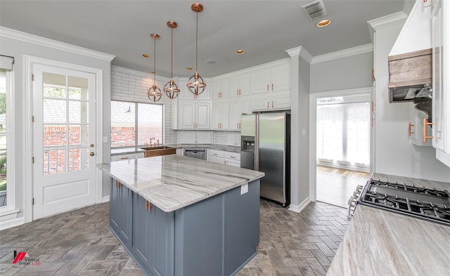 kitchen featuring visible vents, appliances with stainless steel finishes, light stone counters, white cabinetry, and pendant lighting