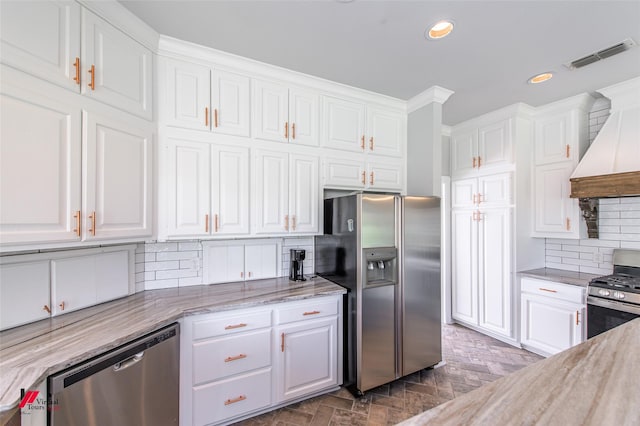 kitchen with appliances with stainless steel finishes, visible vents, custom exhaust hood, and white cabinetry