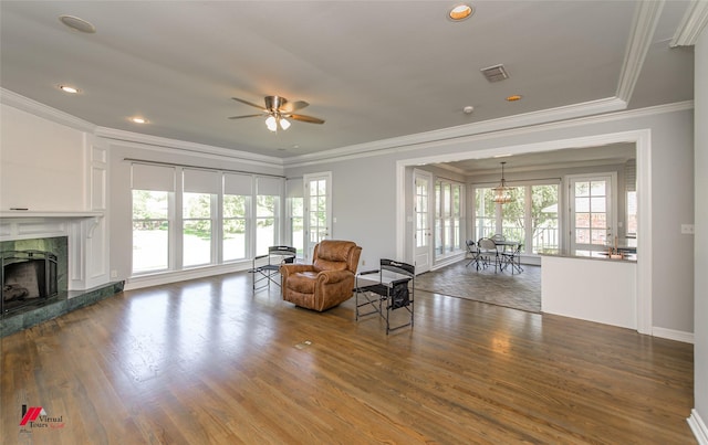 unfurnished room with plenty of natural light, visible vents, wood finished floors, and a high end fireplace