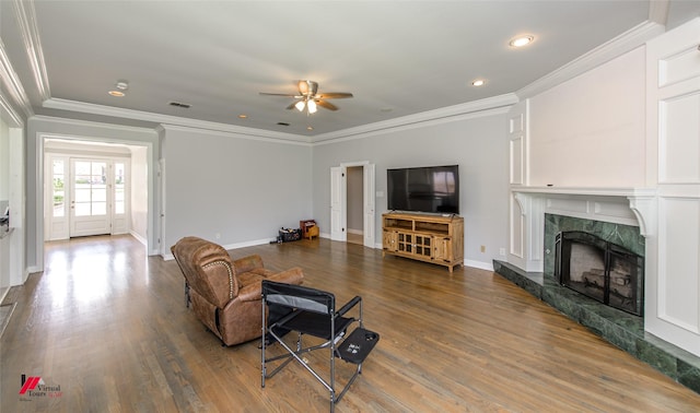 living area with wood finished floors, a high end fireplace, visible vents, and baseboards