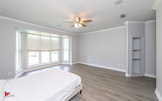 bedroom featuring ornamental molding, wood finished floors, and baseboards