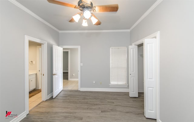 unfurnished bedroom featuring light wood-style flooring, baseboards, and crown molding