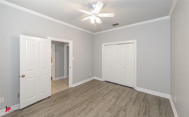 unfurnished bedroom with light wood-style flooring, visible vents, ornamental molding, and baseboards