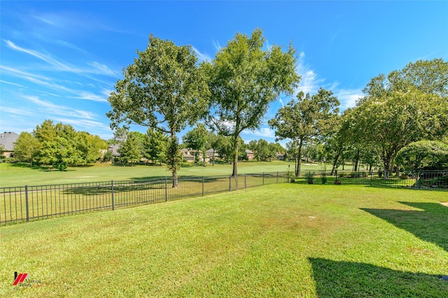 view of yard with fence and a rural view