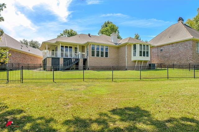 back of house with a fenced backyard, a chimney, stairway, and a yard