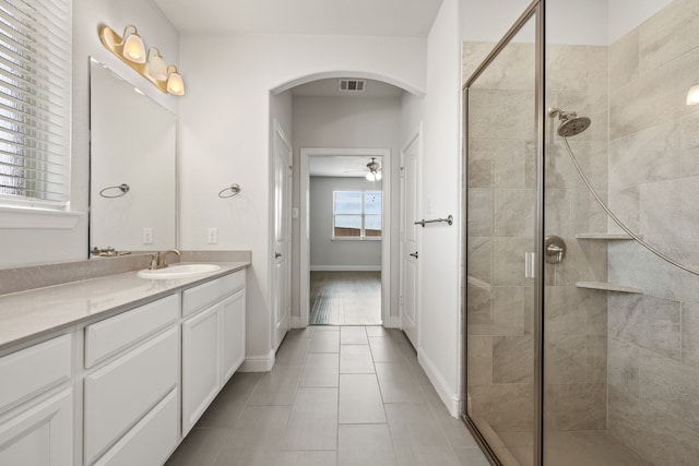 bathroom featuring vanity, ceiling fan, tile patterned floors, and walk in shower