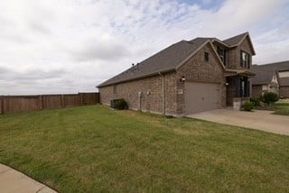 view of property exterior with a garage, a lawn, and cooling unit