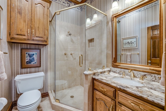 bathroom with vanity, toilet, and a shower with door