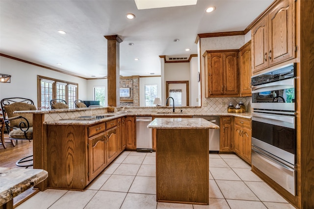 kitchen with kitchen peninsula, a kitchen island, a healthy amount of sunlight, and a breakfast bar area