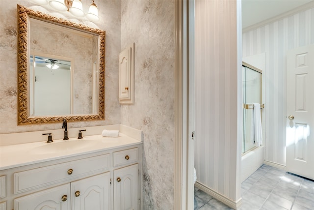 bathroom with tile patterned floors, ceiling fan, vanity, and bath / shower combo with glass door