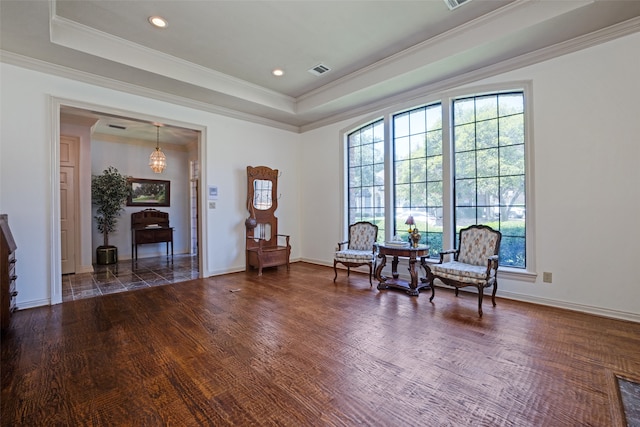 living area featuring a tray ceiling, crown molding, and dark hardwood / wood-style floors