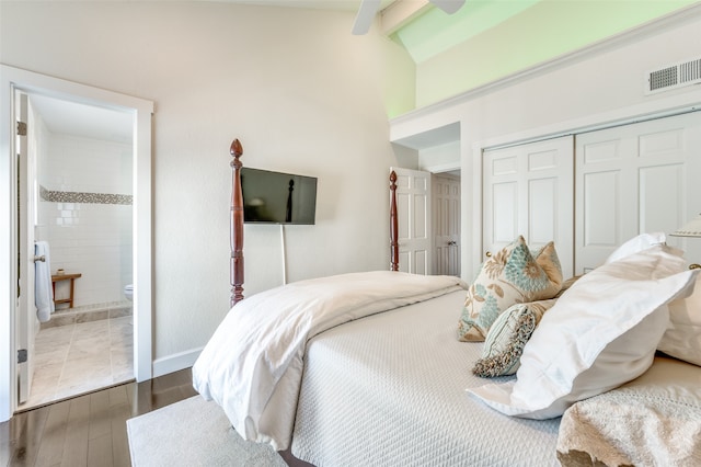 bedroom with lofted ceiling with beams, a closet, ceiling fan, connected bathroom, and hardwood / wood-style flooring