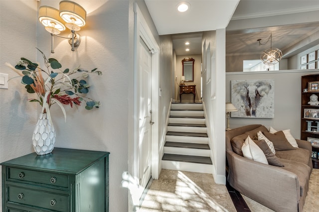 hallway featuring a notable chandelier, light colored carpet, and ornamental molding