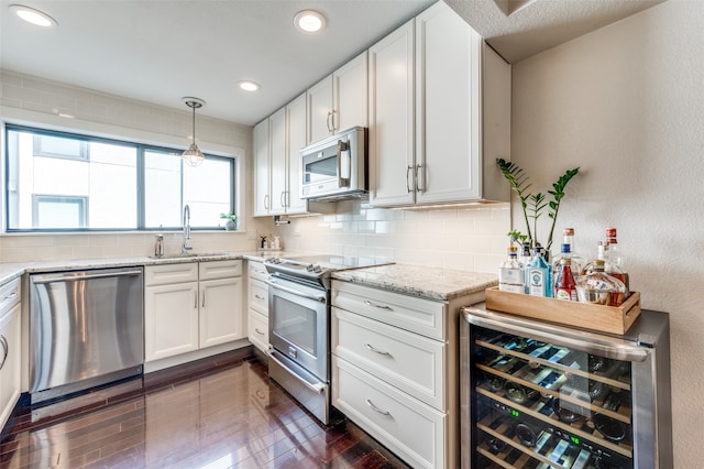 kitchen with decorative backsplash, white cabinets, wine cooler, sink, and stainless steel appliances