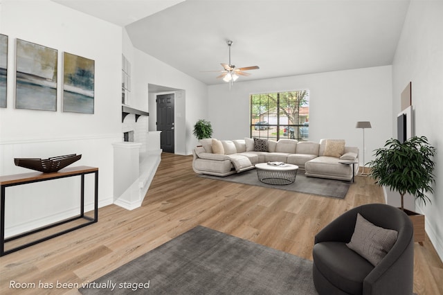 living room featuring lofted ceiling, ceiling fan, and light hardwood / wood-style floors