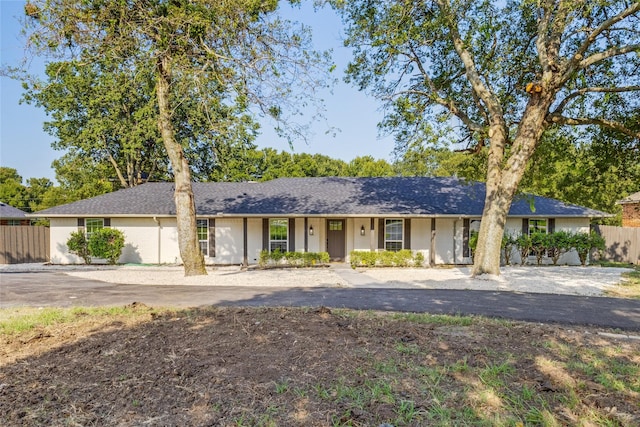 ranch-style home featuring fence