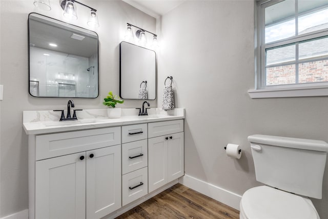 bathroom featuring toilet, a shower, vanity, and hardwood / wood-style flooring