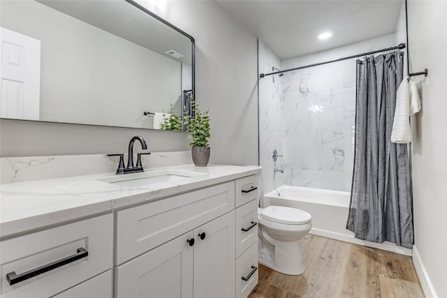 full bathroom featuring hardwood / wood-style floors, shower / bath combo with shower curtain, vanity, and toilet