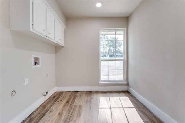 laundry area with hookup for a gas dryer, light wood-type flooring, cabinets, and washer hookup