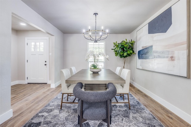 dining space with an inviting chandelier and hardwood / wood-style flooring